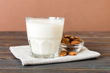 Top view of the almond milk in the glass bottle with almond nuts on the colored table. top view vith copy space