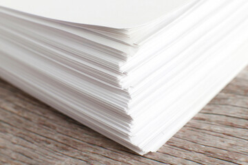 White paper on wooden background, stack