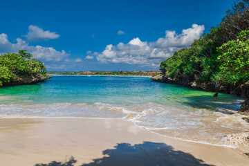 Fototapeta na wymiar Holiday beach with tropical trees, sand and blue ocean.