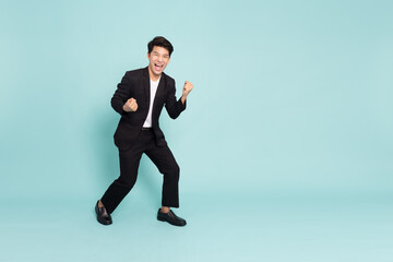 Fototapeta na wymiar Young Asian business man shout loudly and be very happy isolated on green background