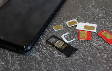 Several SIM cards and a memory card lying next to the smartphone
