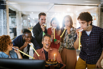 Group of young people celebrating a birthday in the office