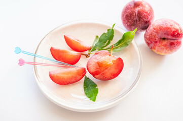 白い皿に盛り付けたスモモ