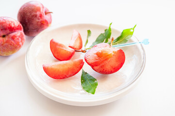 白い皿に盛り付けたスモモ