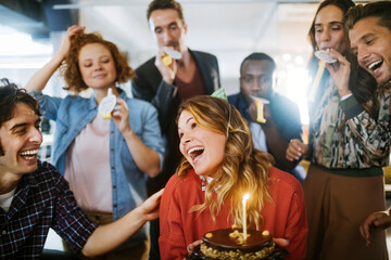 Fototapeta premium Group of young people celebrating a birthday in the office