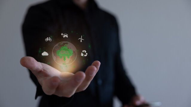 Hand holding virtual Global with CO2 reducing icon for concept of decrease carbon dioxide emission ,carbon footprint and carbon credit to limit global warming from climate change concept.