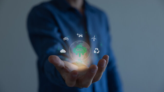 Hand holding virtual Global with CO2 reducing icon for concept of decrease carbon dioxide emission ,carbon footprint and carbon credit to limit global warming from climate change concept.