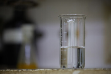 An old measuring beaker with a scale on a blurry background