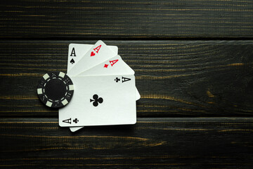 Poker game with four of a kind or quads combination. Chip and cards on the black vintage table in...