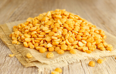 Yellow dried peas on wooden background, split pea