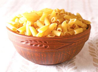 Penne rigate pasta from durum wheat in brown plate