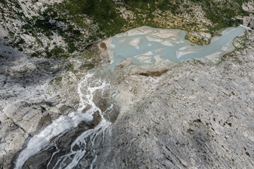 aerial view of the waterfalls and lake produced by the Adamello glacier in Trentino