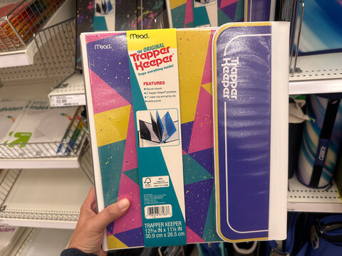 Plymouth, Minnesota - July 30, 2023: Hand holds up a throwback 1990s trapper keeper portfolio folder system on sale at a Target store