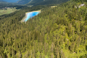 panoramic aerial view of montagnoli lake surrounded by a fir forest in trentino