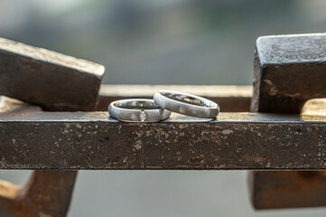 Two hands with wedding rings rest on a strong anchor chain