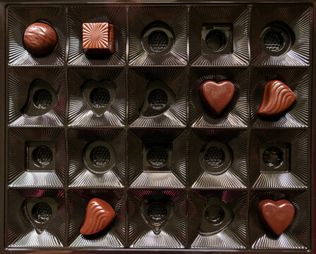 A square box with a small amount of chocolates. An almost empty box of chocolates