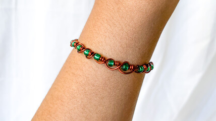 brown skin asian hand with wire bracelet