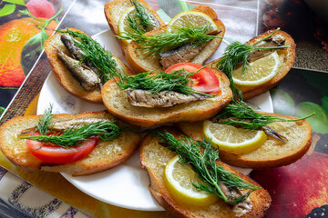 Croutons with sprats, tomato, lemon and dill. Traditional Slavic meal for the holidays