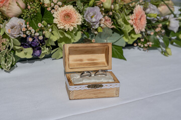 wedding ring pillow burlap in wooden box in front of flower bouquet rings of love - 629661763