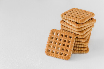 A stack of sugary square cookies on a white background. Copy space.