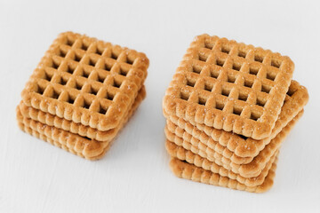 Stacked sweet square cookies on a white background.