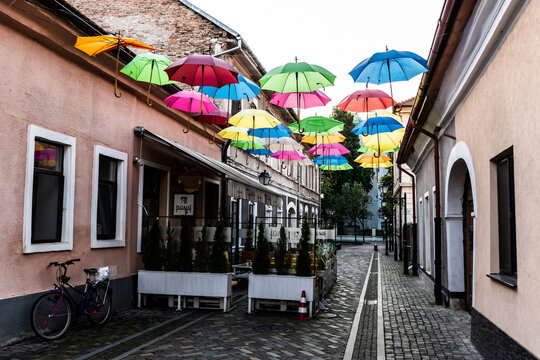 Pedestrian street with colored umbrellas in the center of Bistrita. Romania.