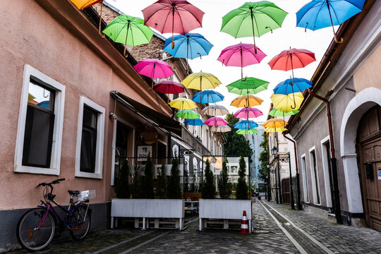Pedestrian street with colored umbrellas in the center of Bistrita. Romania.