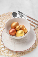 Beautiful table setting with Easter eggs on white background