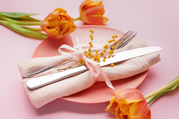 Table setting with beautiful tulip flowers on pink background