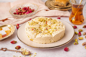 Plate of tasty Tahini halva with pistachios on light background