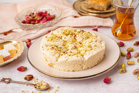 Plate of tasty Tahini halva with pistachios on light background