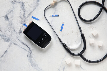 Fototapeta na wymiar Glucometer with strips, sugar and stethoscope on grunge background. Diabetes concept