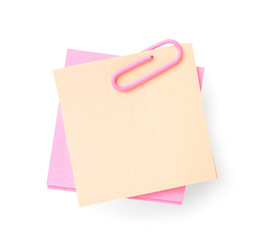 Pink and beige sticky notes with paper clip on white background