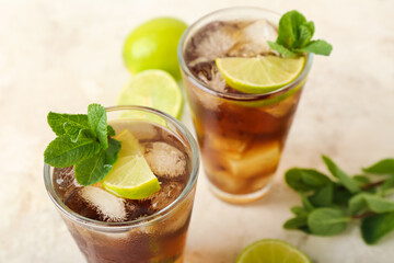 Glasses of tasty Cuba Libre cocktail on light background, closeup