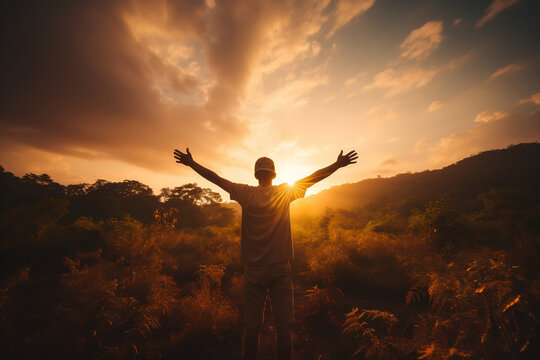 Serenity in Sunset, Silhouette of young man embracing freedom with open arms at sunset