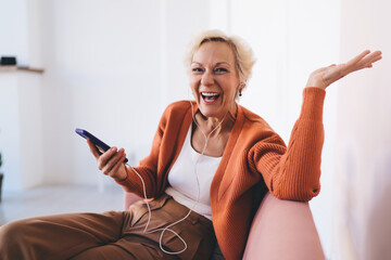 Cheerful elderly woman listening to favorite music