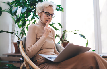 Thoughtful woman in eyeglasses studying at home