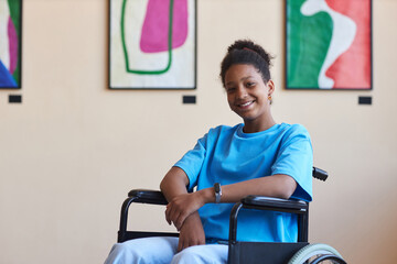 Colorful portrait of black teenage girl with disability smiling at camera while visiting modern art...