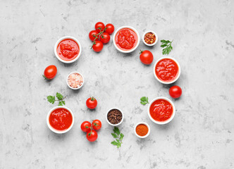 Frame made of bowls with tasty tomato sauce and ingredients on grunge background