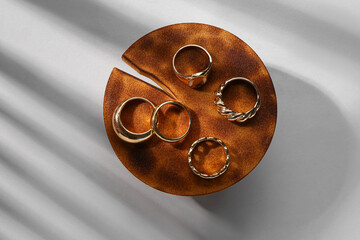 Decorative stand with beautiful golden rings on grey background