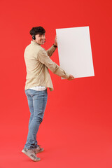 Male technical support agent with blank poster on red background