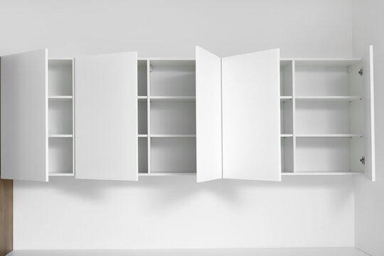 White cupboards hanging on light wall in kitchen