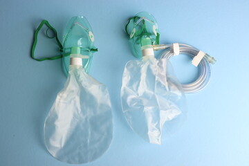 Top view of an Adult and pediatric oxygen mask in a light blue background.