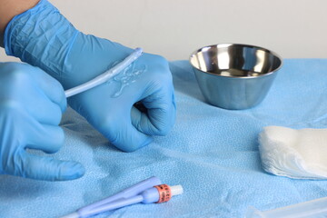 Foley catheter in a healthcare professional passing the lubricant in the catheter tip