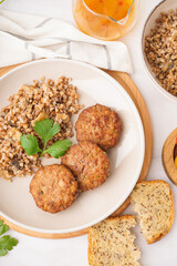 Cutlets with buckwheat, mushrooms and parsley on white table in kitchen