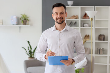 Male wedding planner with clipboard working in office