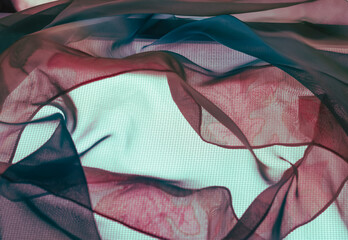 Text space center is surrounded with translucent fabrics in maroon and blue with leaf pattern....