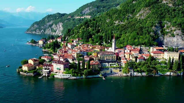 Aerial 4K footage of Varenna, Como Lake. Drone panoramic view of town surrounded by mountains, blue sky and turquoise water and located in Como Lake, Lombardy, Italy