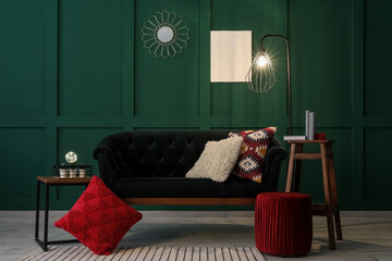 Interior of living room with green sofa, coffee table and glowing lamp
