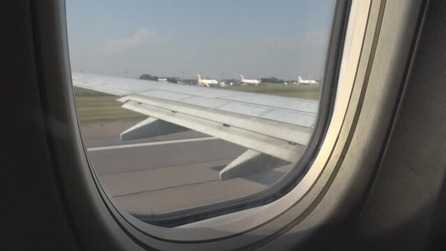 Airplane window view of take off departure from airport runway